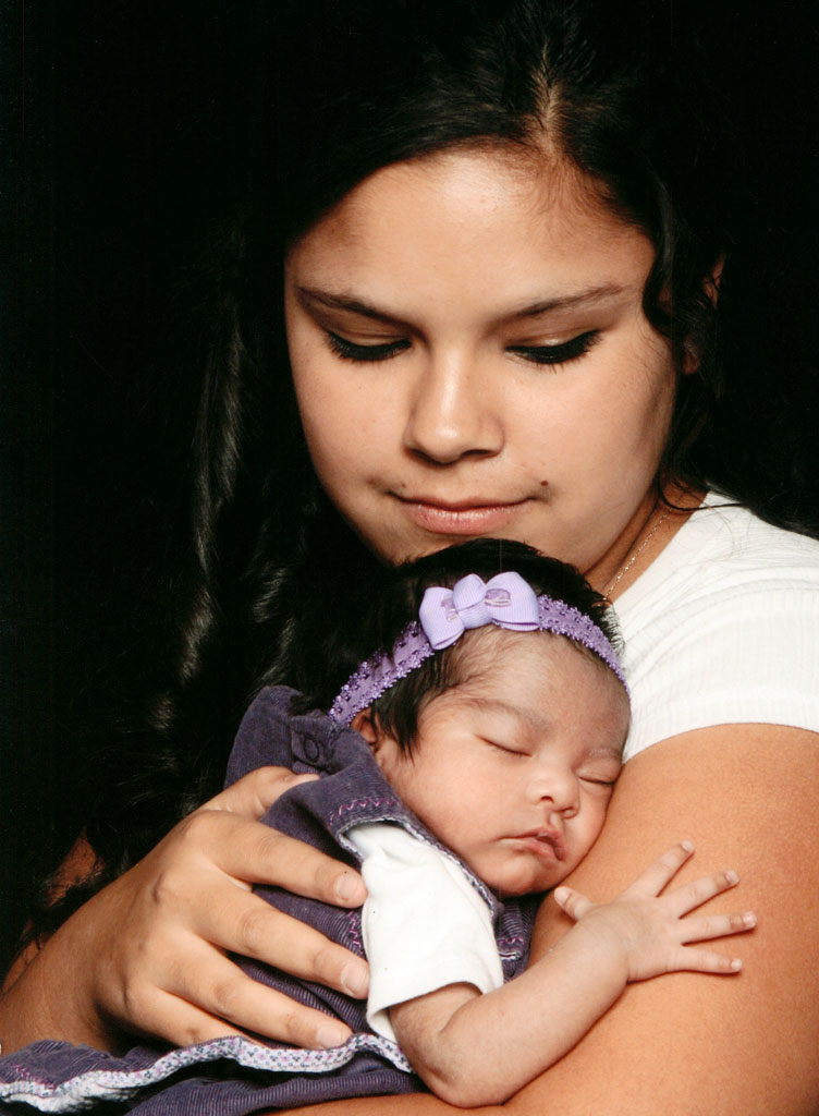 A woman holding a baby in her arms.